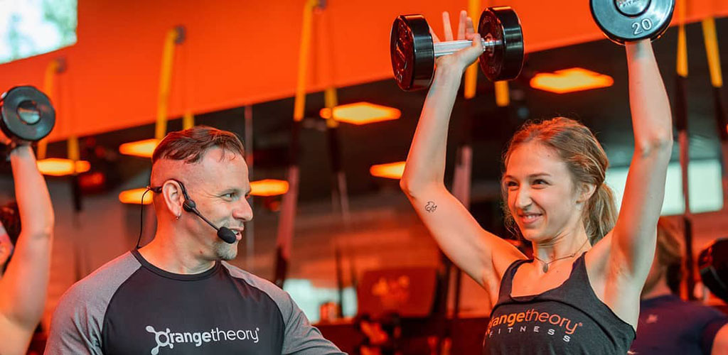 Lifting weights with an instructor from Orange Theory Fitness