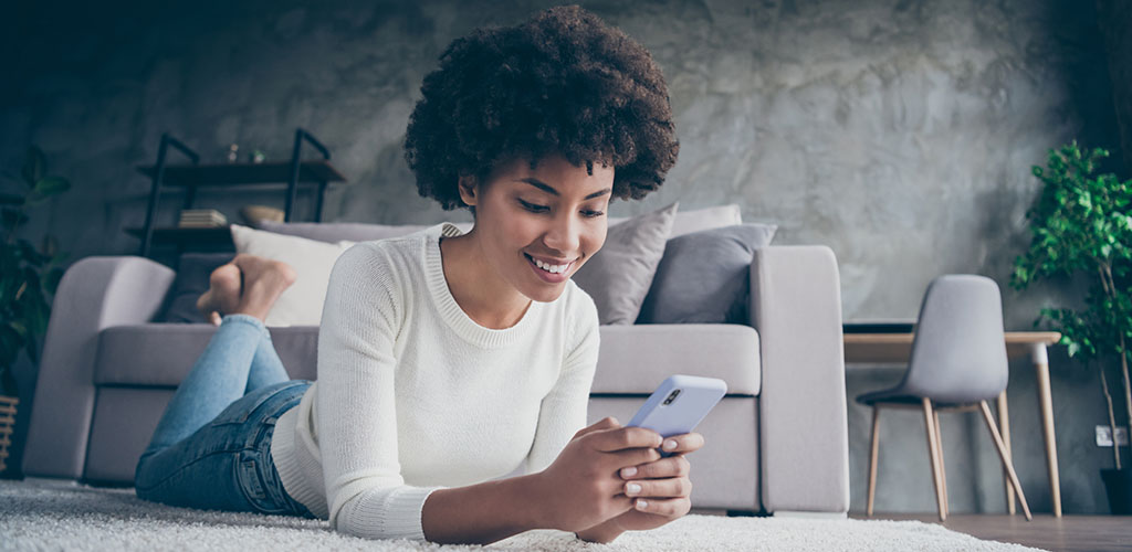 A woman smiling while texting someone