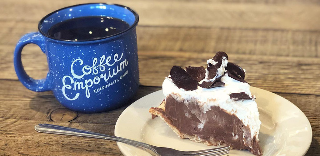 A blue prsopector's mug of coffee with a piece of chocolate pie