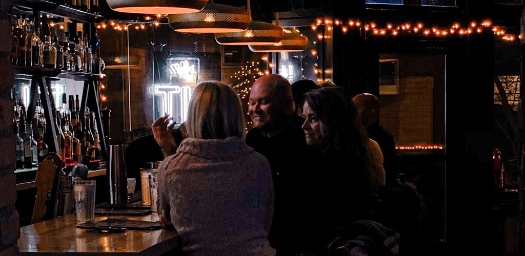 Friends having a drink at Literary Tavern in a dark, intimate setting