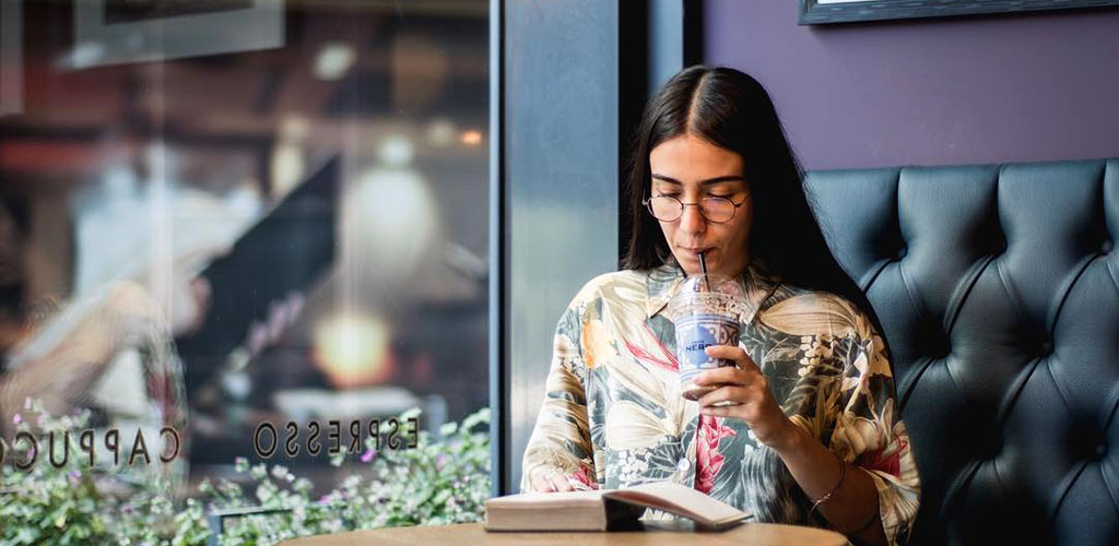 A Manchester girl reading a book and enjoying coffee at Caffe Nero