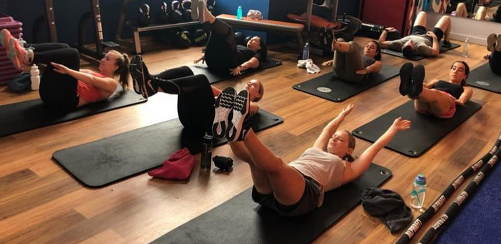 Newcastle singles stretching in a yoga class at Plus Fitness