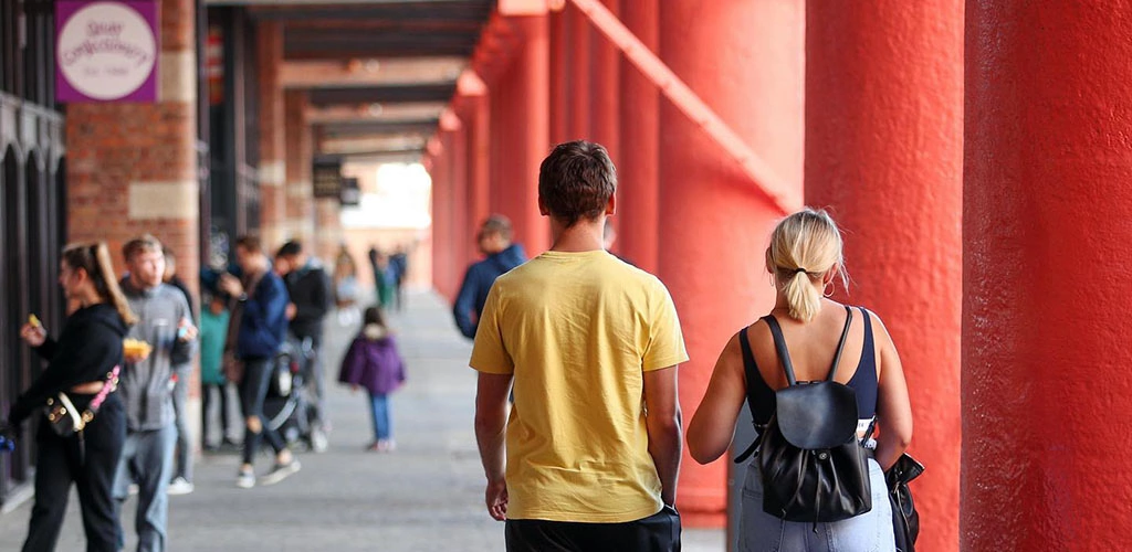 A couple walking along the Royal Albert Dock