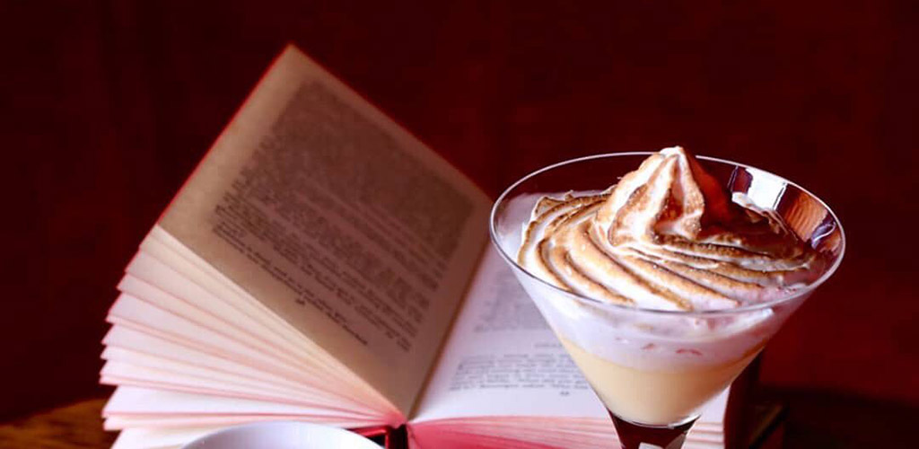 A creamy cocktail and a book from The Library