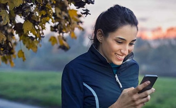 A woman taking a break from jogging to try the best Riverside dating apps