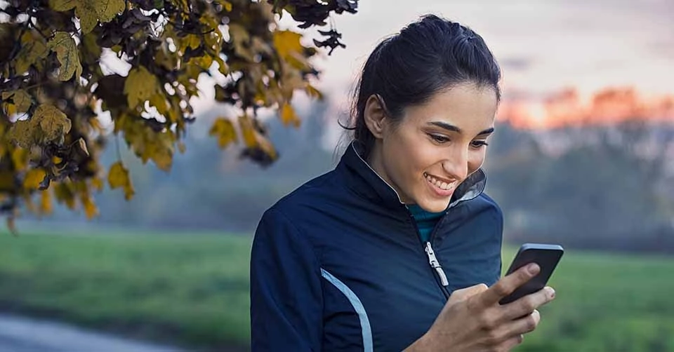 A woman taking a break from jogging to try the best Riverside dating apps