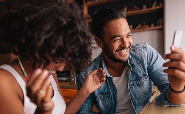 Couple in a cafe laughing about the things to talk about with your crush