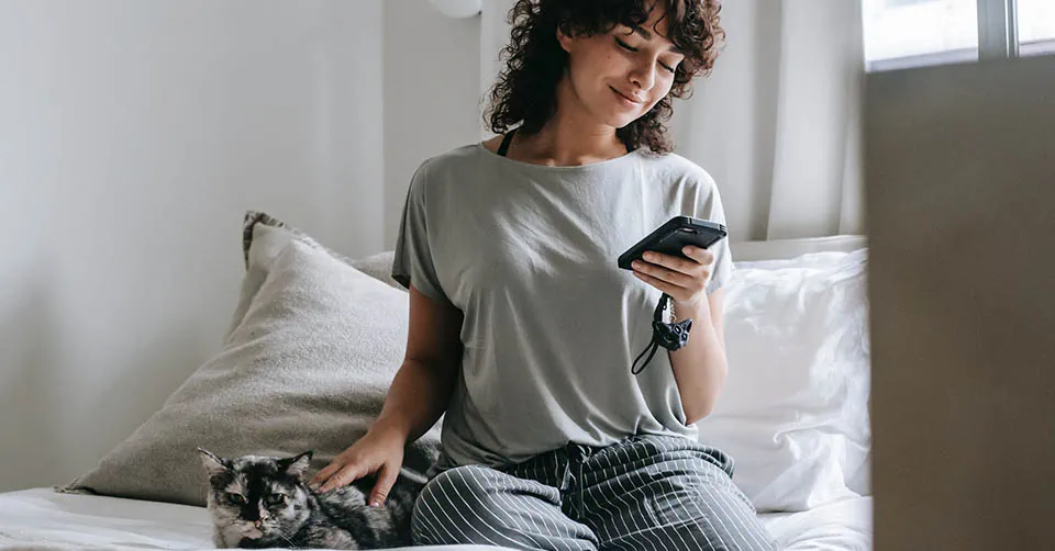 She's smiling because she's texting a guy who knows how to build sexual tension over text