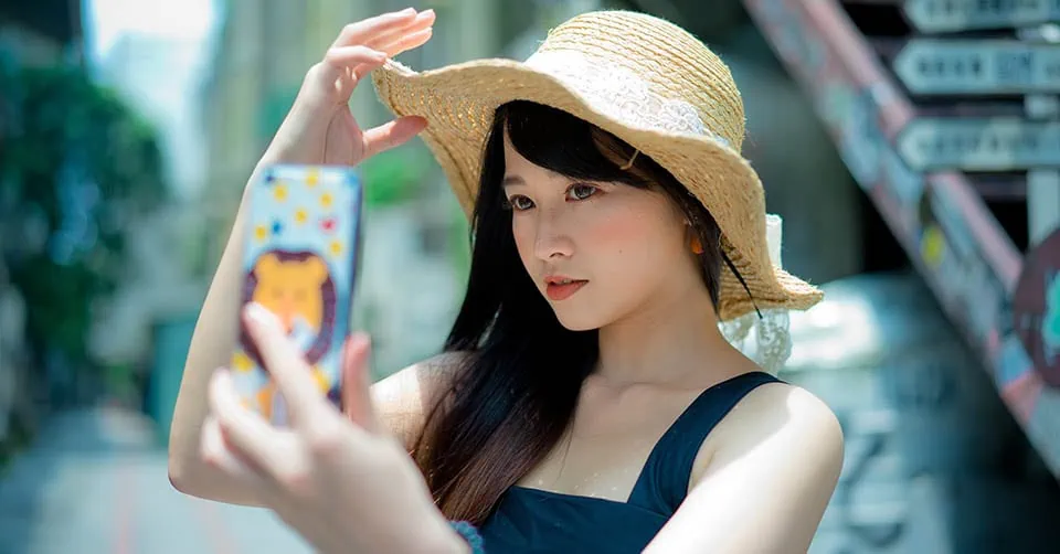 A pretty woman taking a selfie in the sun