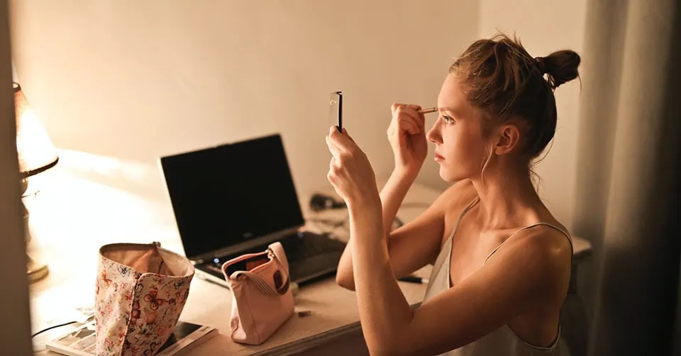 Woman applying makeup before going out