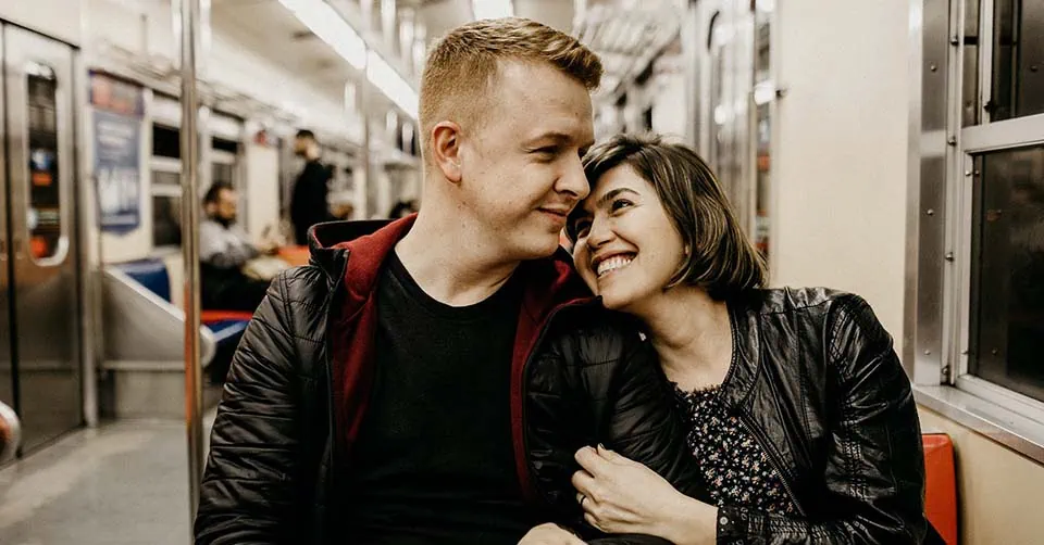 A couple being affectionate on the train