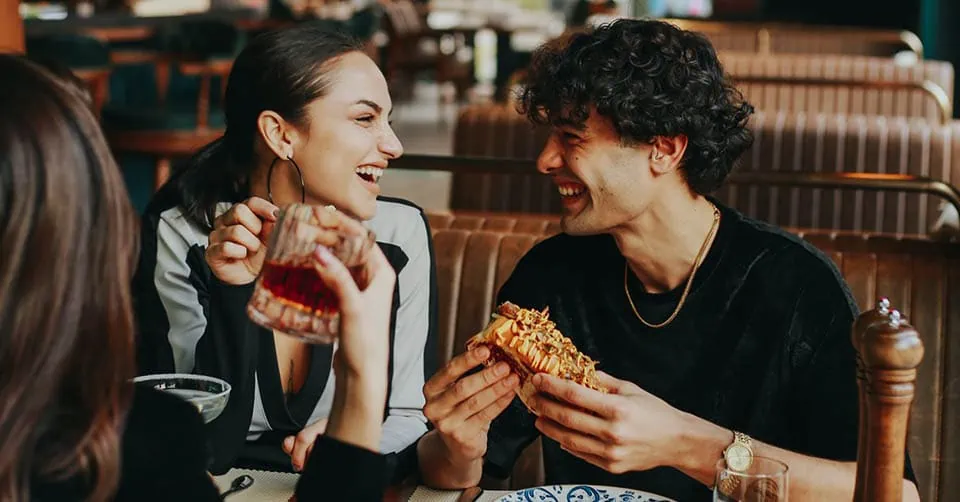 He's using emotional contagion seduction to get her to laugh with him