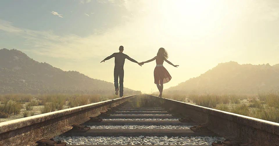 A couple balancing on the tracks