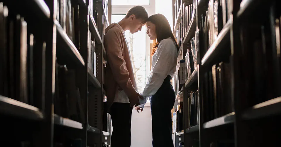 A couple reconciling in a library