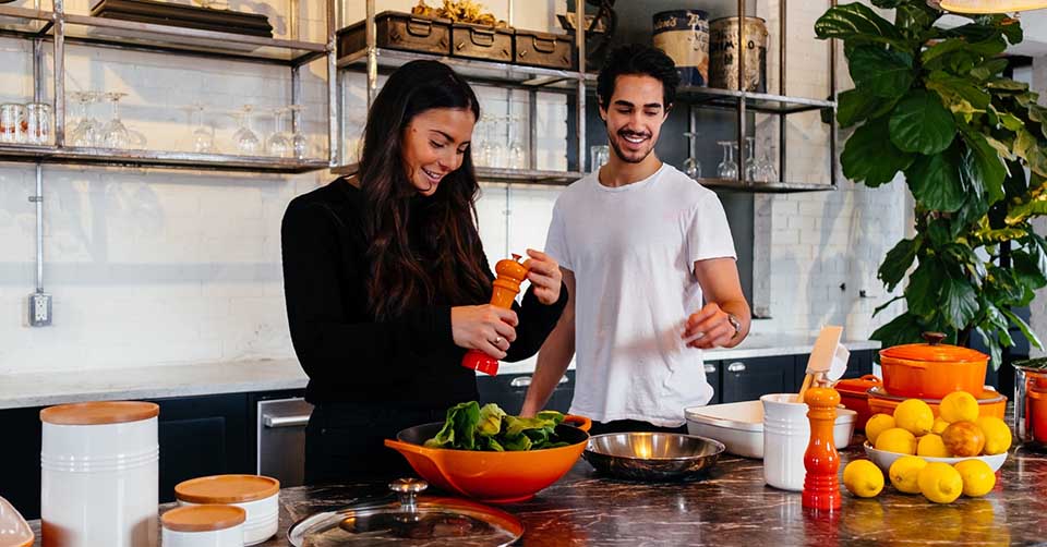 A man helping his girlfriend cook