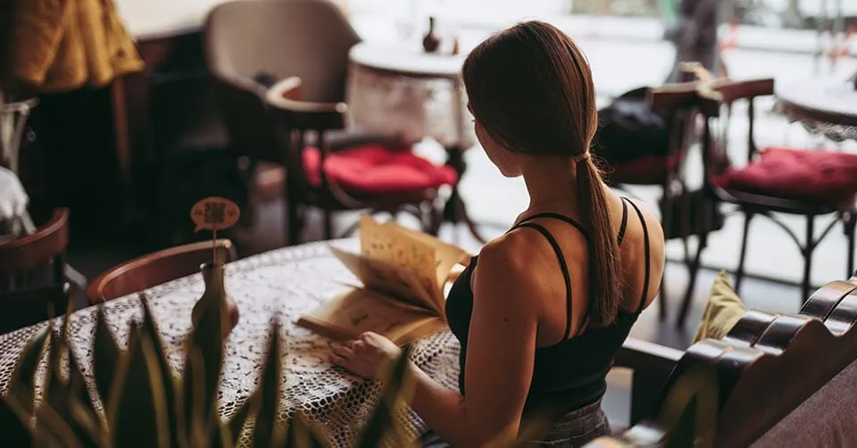 A woman reading a book in a coffee shop