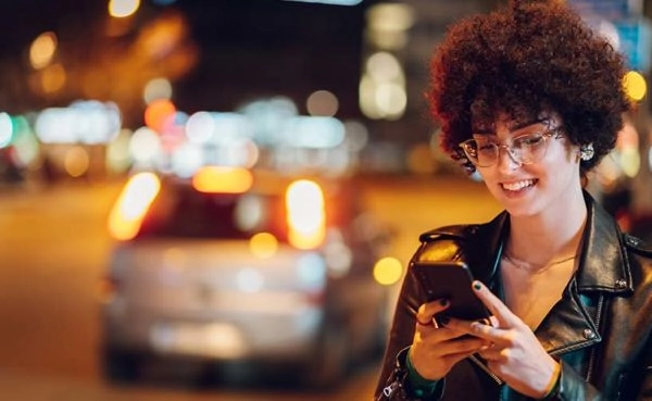 A sexy woman checking out the top dating apps in New Jersey at night