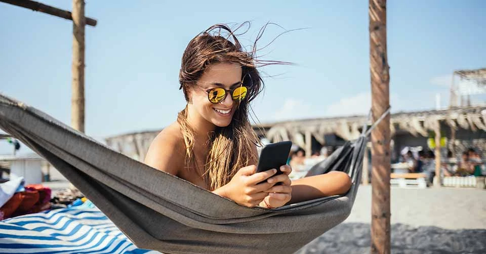 A beautiful woman using a San Juan dating app at the beach