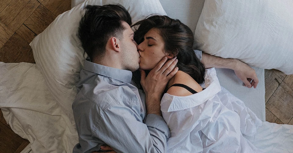 A couple kissing in bed