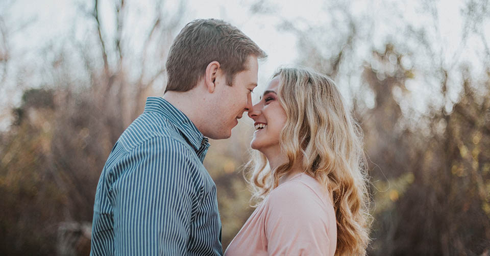 A couple kissing on a bridge