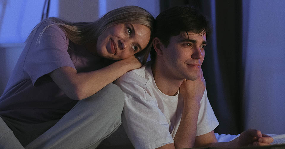 A couple watching TV in bed