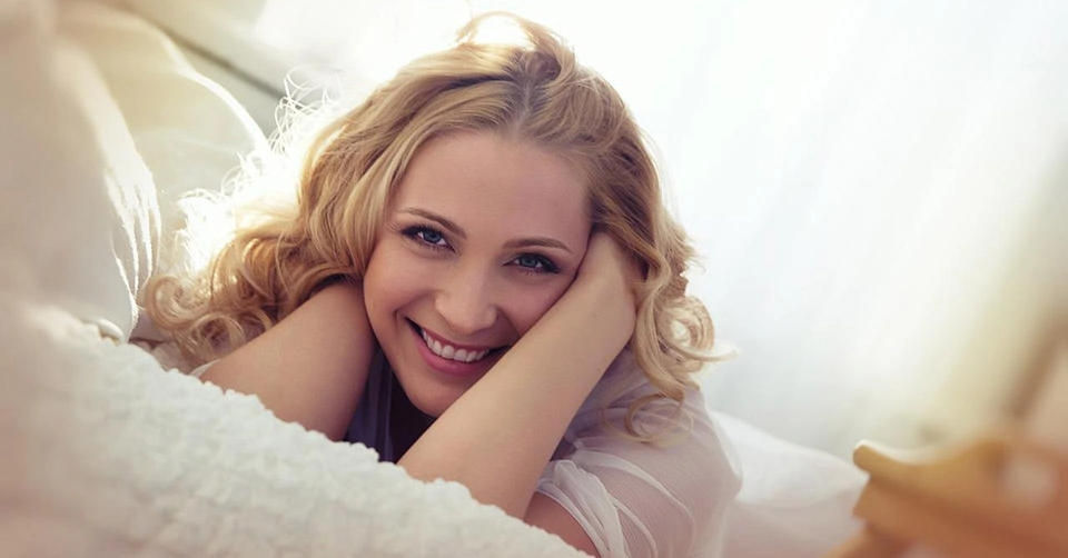 A woman smiling in bed