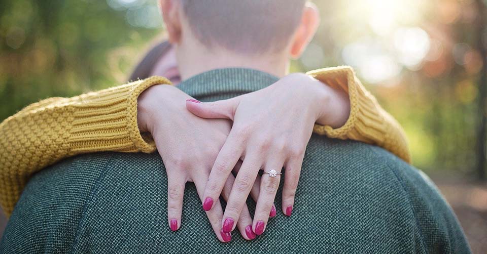 An engaged couple hugging