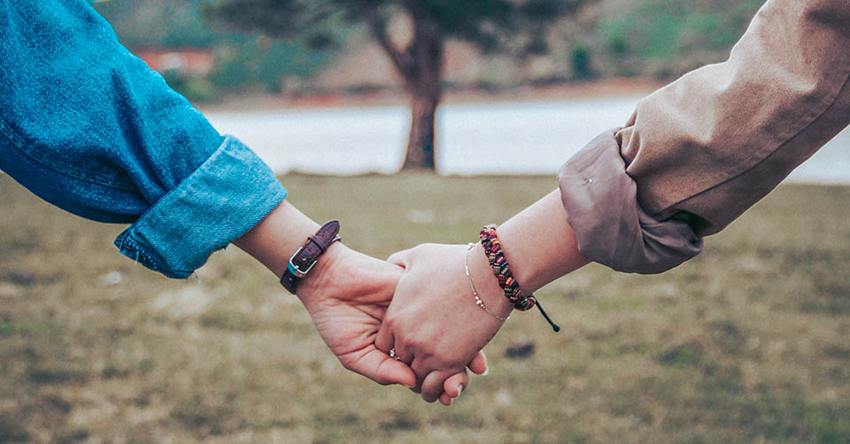 Couple holding hands by a tree