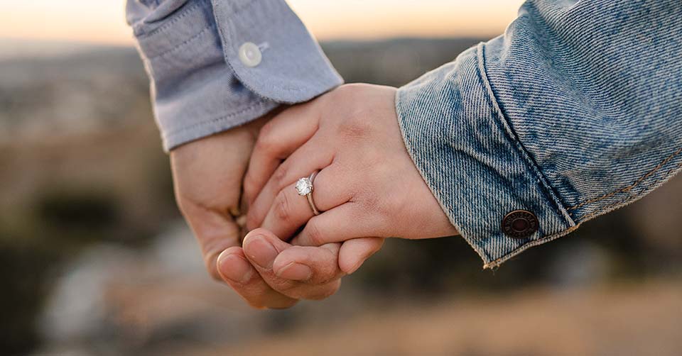 Engaged couple holding hands