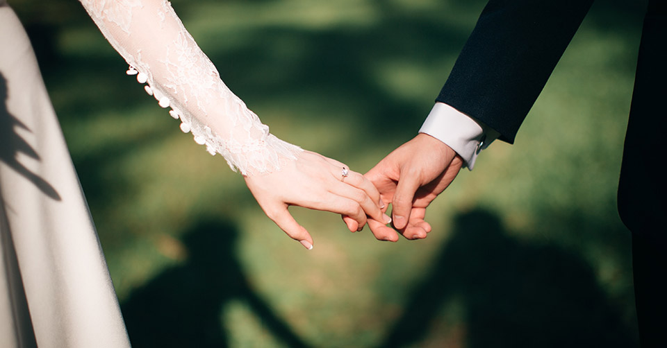 Married couple holding hands during their wedding