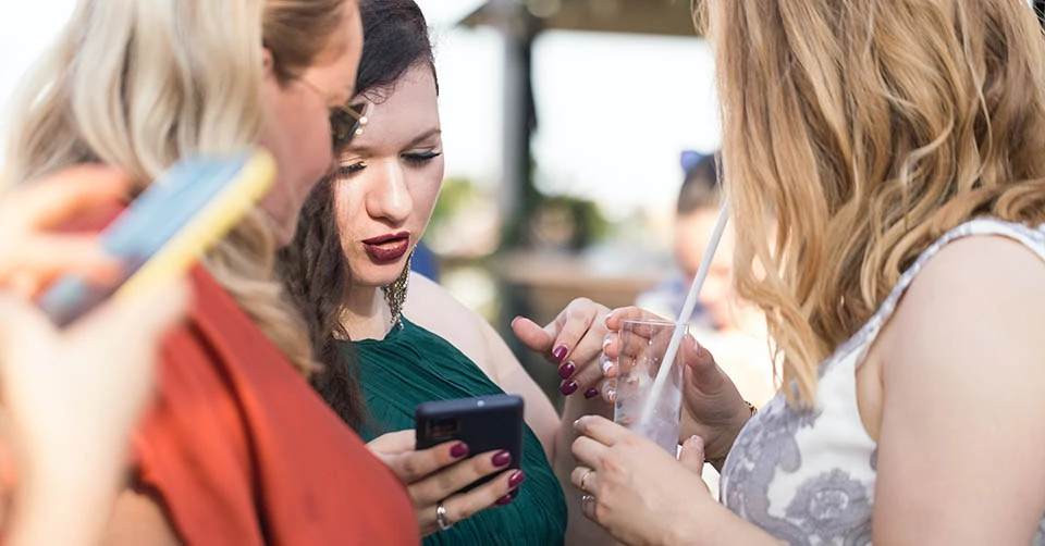 Showing her friends a match she got on a free dating app