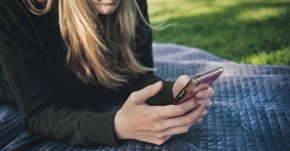 Woman texting in a park