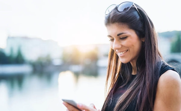 A sexy brunette smiling while using her favorite Arkansas dating apps