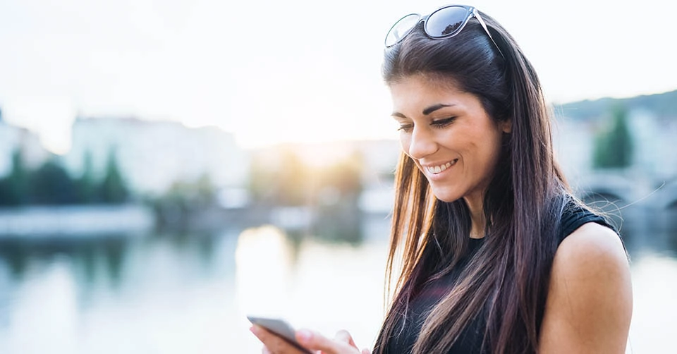 A sexy brunette smiling while using her favorite Arkansas dating apps