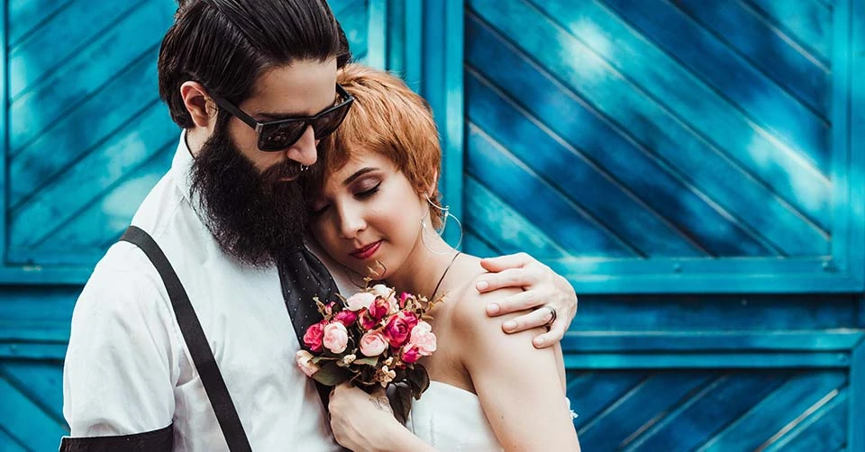 Married couple posing near a barn door