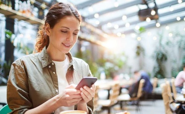 A woman at a cafe using her favorite West Virginia dating app