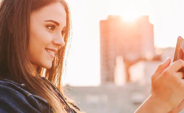 A young woman in a denim jacket trying an Idaho dating app