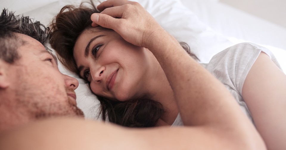 A couple cuddling in bed